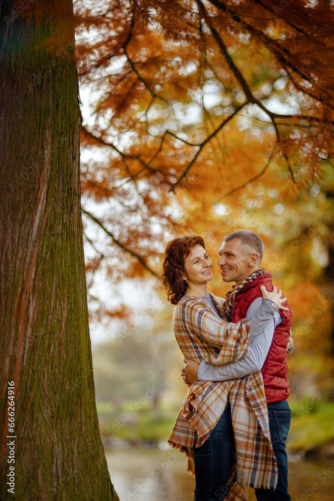 Fototapeta premium happy stylish couple in park embracing near tree