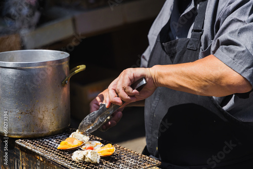 chef at a street kitchen preparing seafood at Tsukiji-market in Tokyo, Japan