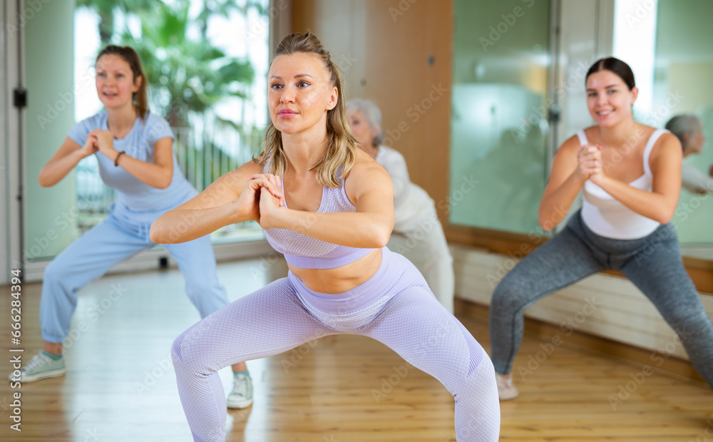 Obraz premium Dynamic middle-aged woman attendee of dance studio doing aerobics during training session. Women training dance in hall