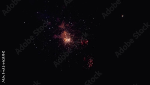 Colored night explosions in black sky. Glowing fireworks show. Shining fireworks with bokeh lights in night sky. Beautiful multi colored fireworks in night sky. New year's eve fireworks celebration