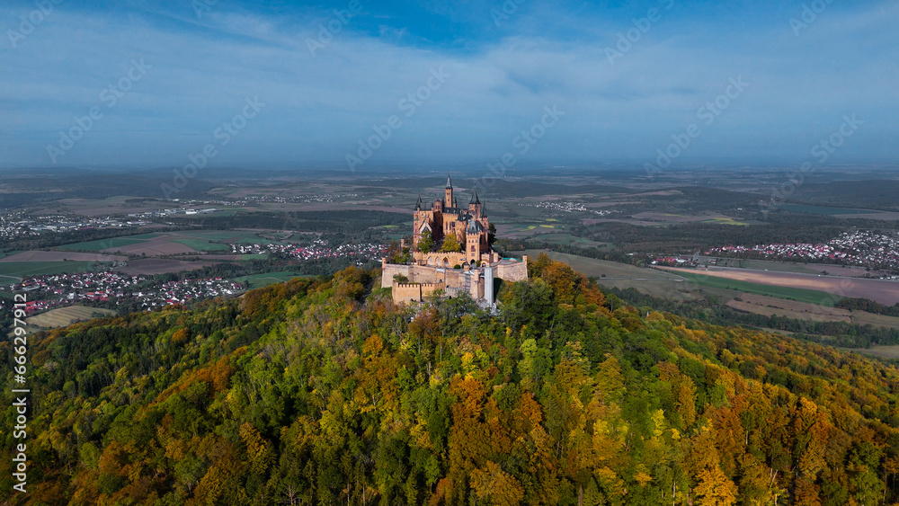 Aerial drone view of medieval Hohenzollern castle on top of hill in autumn, Baden-Wurttemberg, Germany Aerial drone view of medieval Hohenzollern castle on top of hill in autumn, Baden-Wurttemberg, Germany