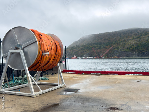 An industrial reel of orange oil sorbents spills containment boom absorbent material for environmental accidents and disasters at sea such as oil spills, chemicals, poison, waste, and toxic materials.