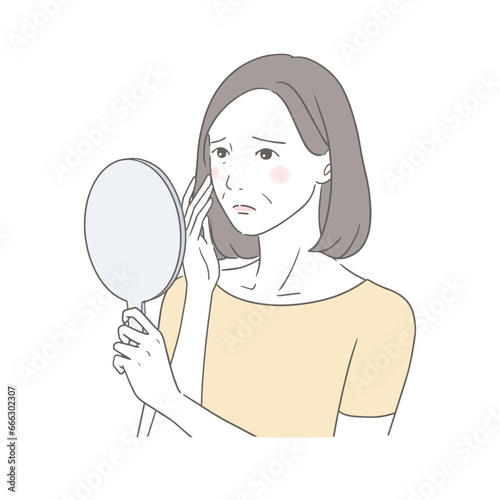 鏡を見て年齢肌に悩む中高年女性