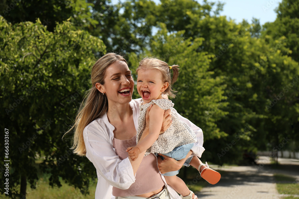 Happy mother with her daughter having fun in park. Space for text Happy mother with her daughter having fun in park. Space for text
