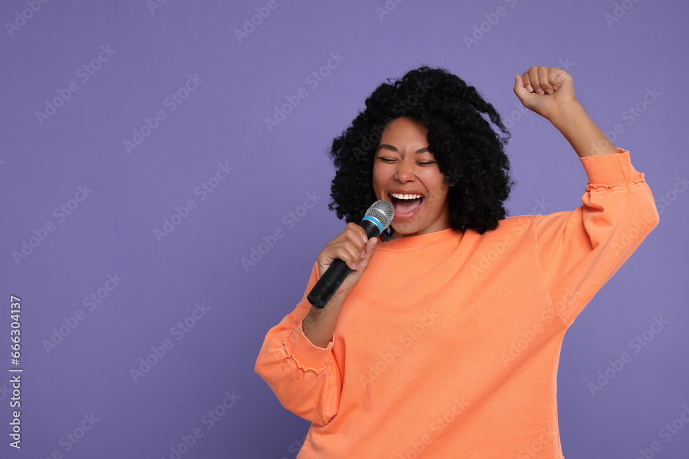 Beautiful woman with microphone singing on violet background, space for text Beautiful woman with microphone singing on violet background, space for text