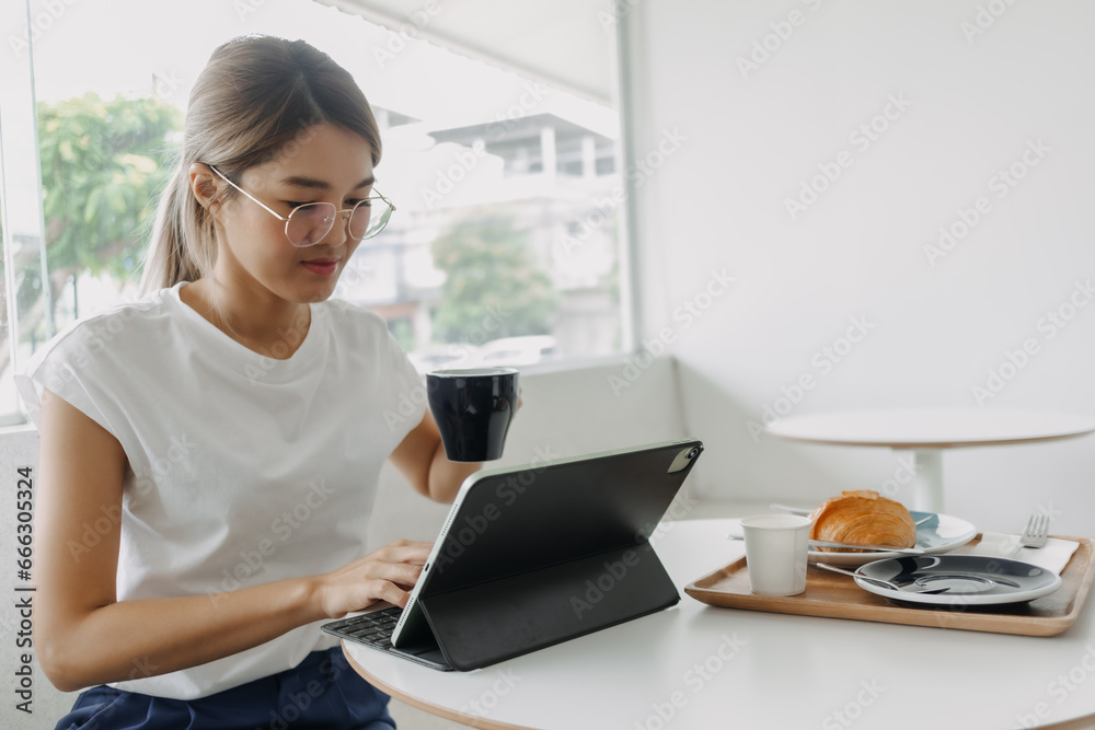 Happy smile freelance asian woman working in the cafe with tablet. Happy smile freelance asian woman working in the cafe with tablet.