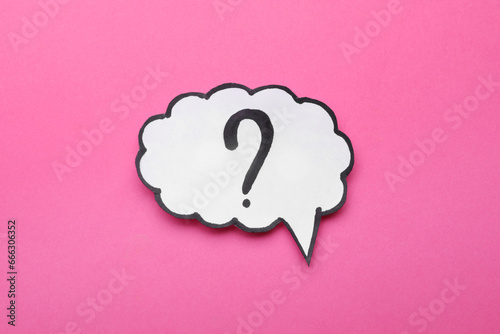 Paper speech bubble with question mark on pink background, top view