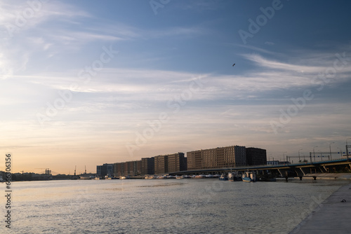 Downtown panorama of the harbor morning sunrise cold weather calm reflection of river water buildings on the horizon, industrial part of the city, panorama city early in the morning time. © Anton