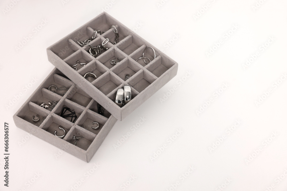 Jewelry boxes with many silver accessories on white table, above view. Space for text Jewelry boxes with many silver accessories on white table, above view. Space for text