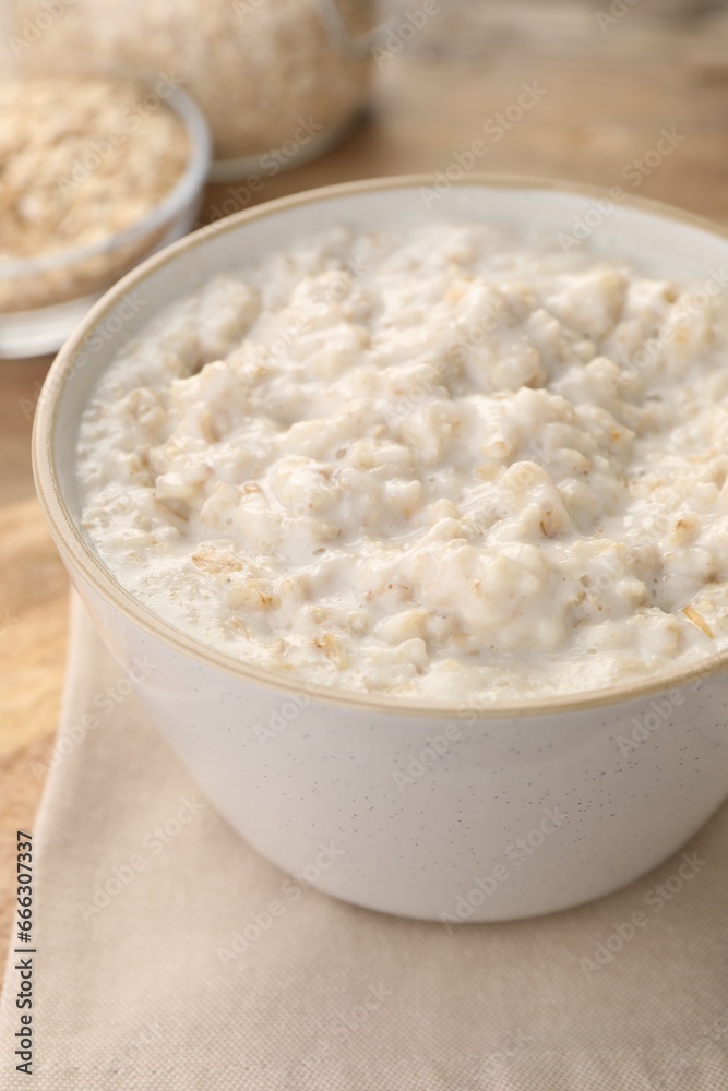 Tasty boiled oatmeal in bowl on table, closeup Tasty boiled oatmeal in bowl on table, closeup