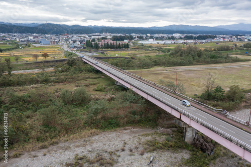 ドローン撮影：信濃川の上にかかる橋と、その上を走る車 
