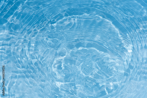 Defocus blurred transparent blue colored clear calm water surface texture with splashes reflection. Trendy abstract nature background. Water waves in sunlight with copy space. Blue watercolor shine.