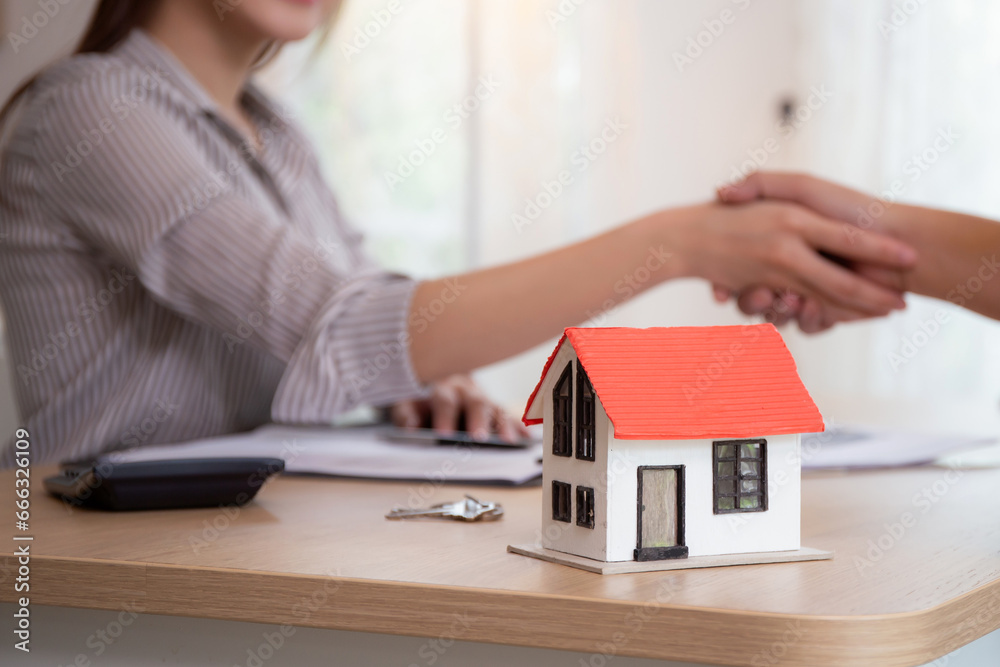 Closeup hands of real estate agent and customer handshake together after agreement together about credit house and insurance, client and consulting of investment about residential, business concept.