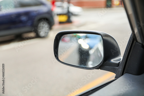 car mirror reflecting urban cityscape, capturing the essence of modern travel and self-reflection