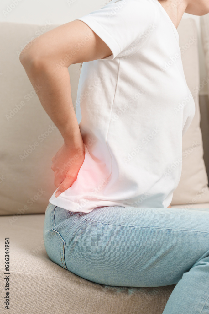 woman having back body ache during sitting on Couch at home. adult female with muscle pain due to Piriformis Syndrome, Low Back Pain and Spinal Compression. Office syndrome and medical concept woman having back body ache during sitting on Couch at home. adult female with muscle pain due to Piriformis Syndrome, Low Back Pain and Spinal Compression. Office syndrome and medical concept