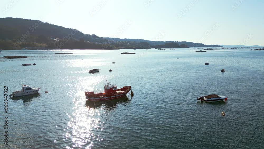 An old fishing boat in a river surrounded by smaller vessels An old fishing boat in a river surrounded by smaller vessels