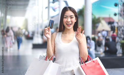 Portrait young beautiful face asian woman holding credit card and shopping bags city lifestyles