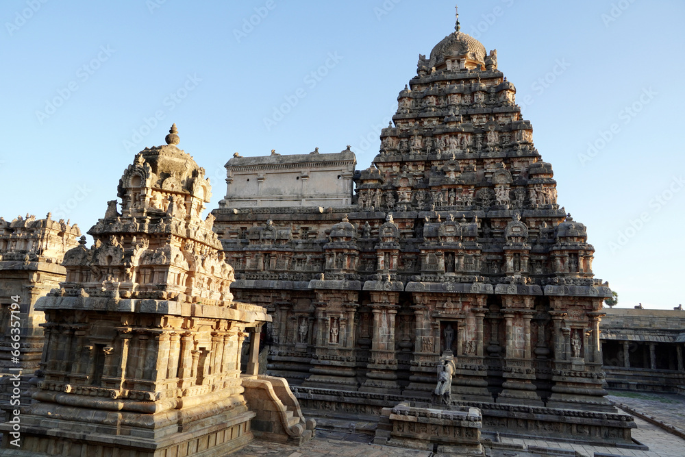 Tower of Airavatesvara Temple, Darasuram, Kumbakonam, Tamilnadu. Ancient hindu temple tower with carvings of God sculpture isolated against blue sky background in Tamilnadu. Tower of Airavatesvara Temple, Darasuram, Kumbakonam, Tamilnadu. Ancient hindu temple tower with carvings of God sculpture isolated against blue sky background in Tamilnadu.