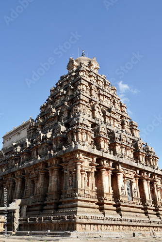 Tower of Airavatesvara Temple, Darasuram, Kumbakonam, Tamilnadu. Ancient hindu temple tower with carvings of God sculpture isolated against blue sky background in Tamilnadu.