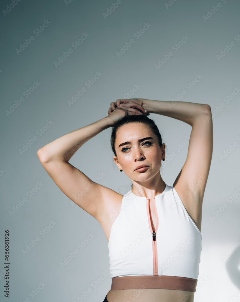 Focused woman preparing hairstyle for training Focused woman preparing hairstyle for training