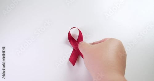 Placing a red ribbon on the center of the frame which signifies the HIV-AIDS worldwide disease awareness and prevention. photo
