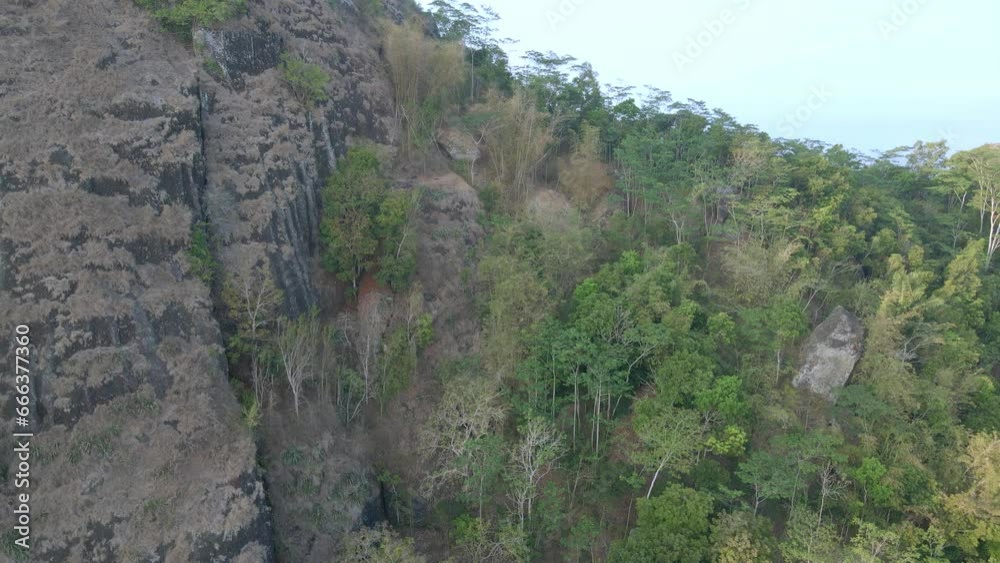 Drone view of Pre historic volcano of Nglanggeran in Gunungkidul, Yogyakarta, Indonesia. Ancient Volcano. Rocky mountains covered with trees. Drone view of Pre historic volcano of Nglanggeran in Gunungkidul, Yogyakarta, Indonesia. Ancient Volcano. Rocky mountains covered with trees.