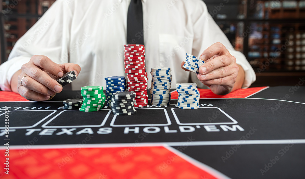 man hold poker chips and makes a bet at casino man hold poker chips and makes a bet at casino