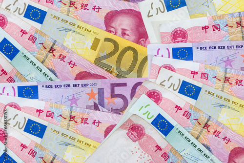 yuan and Euro banknotes on wooden background.