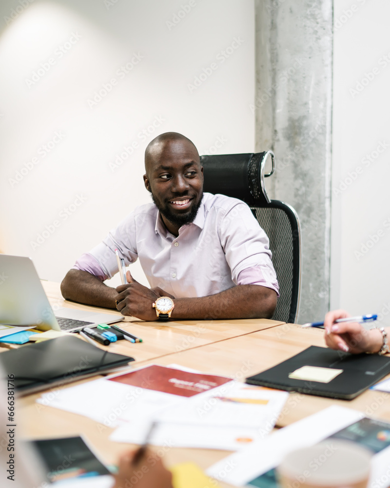 Glad black employee doing project with coworkers Glad black employee doing project with coworkers