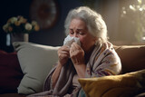A sick old woman blows her nose with a handkerchief in the living room