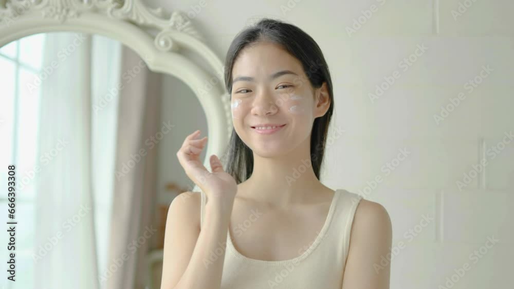 Slow motion portrait young asian woman uses creams on her face. Concept for fresh moisturized skin beautiful close up cosmetic face happy healthy model. Young black hair girl take care of her skin. Slow motion portrait young asian woman uses creams on her face. Concept for fresh moisturized skin beautiful close up cosmetic face happy healthy model. Young black hair girl take care of her skin.