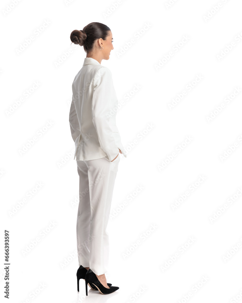 side and back view of elegant woman in white suit holding hands in pockets side and back view of elegant woman in white suit holding hands in pockets