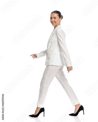 elegant young woman in white suit walking and being happy © Viorel Sima