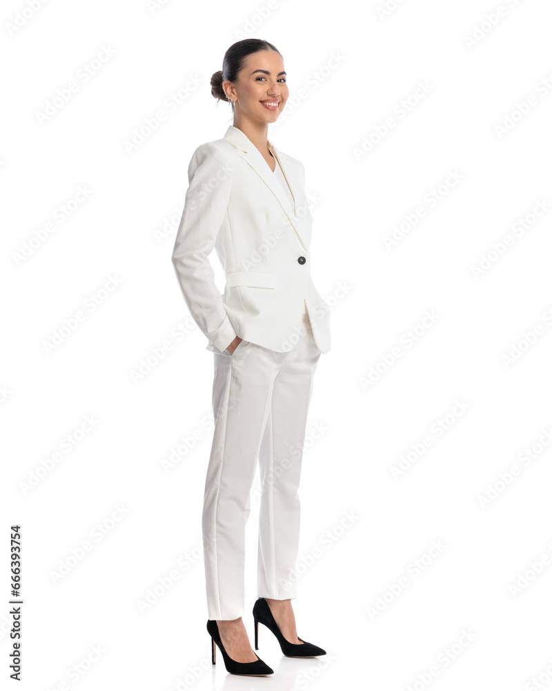 sexy young woman in white suit holding hands in pockets and smiling sexy young woman in white suit holding hands in pockets and smiling