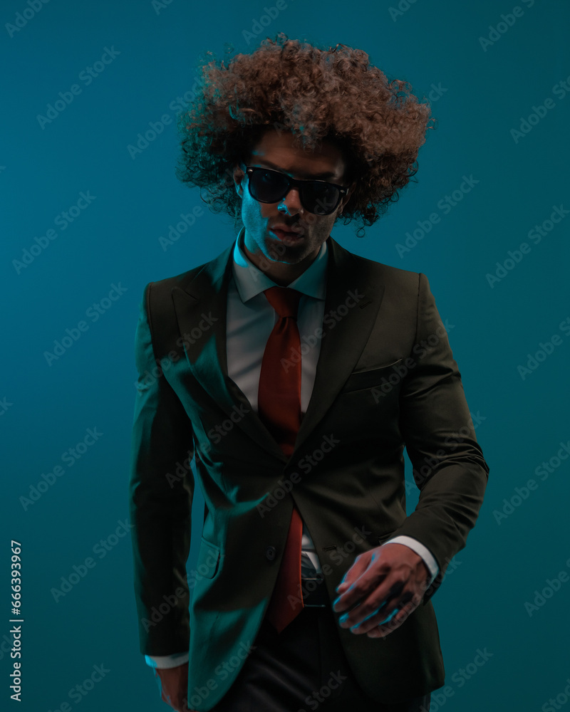 cool fashion man with sunglasses in black suit moving and walking cool fashion man with sunglasses in black suit moving and walking