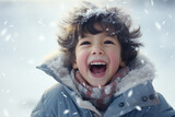 A boy in winter clothes plays in the snow in front of the house