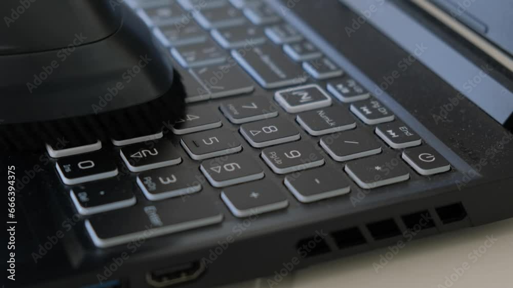 Close-up vacuum cleaner cleaning the keyboard on a laptop Close-up vacuum cleaner cleaning the keyboard on a laptop
