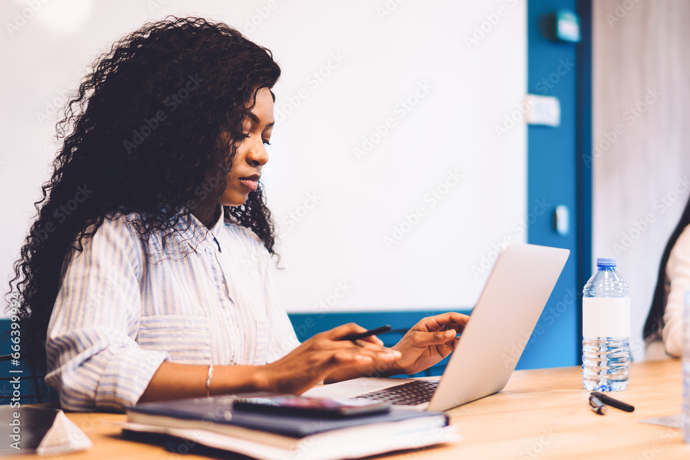 Black office employee working on laptop Black office employee working on laptop