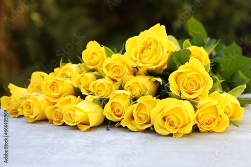 Beautiful bouquet of yellow roses on light table outdoors