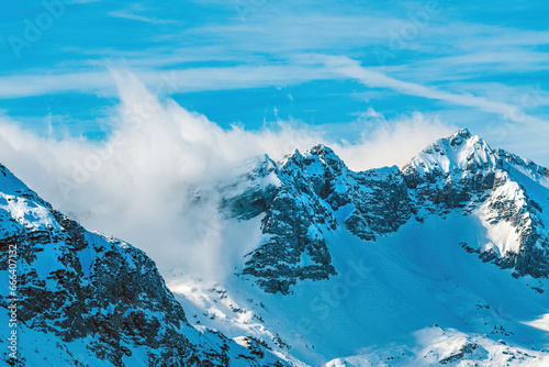 Fototapeta Naklejka Na Ścianę i Meble -  Clouds rolling over snowcapped mountain top in Julian Alps range during winter
