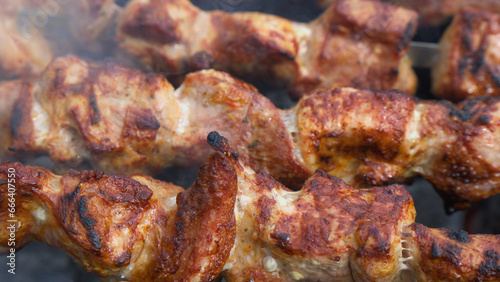 Cooking meat skewered on hot coals.