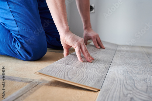 Εκτύπωση καμβά Close up of man construction worker installing laminate timber flooring in apartment under renovation