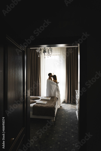 Couple in love posing in blankets in a hotel room in the mountains. Concept for a vacation in the mountains © Darius