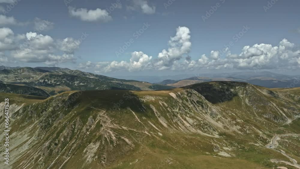 Majestic view of the Transalpina mountains in Romania, showcasing rugged terrains, winding roads, and dramatic clouds. Majestic view of the Transalpina mountains in Romania, showcasing rugged terrains, winding roads, and dramatic clouds.