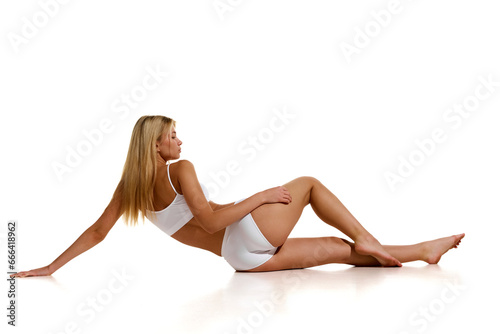 Rear view photo of slim, fit, female body, buttocks in white lingerie isolated over light background. Anti-cellulite cosmetology. Fitness.