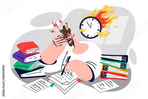 Man office clerk cannot cope with deadlines, sitting at desk littered with papers near burning clock