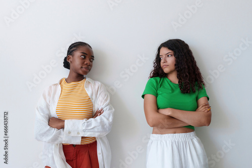 Angry friends with arms crossed standing in front of wall photo