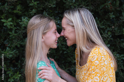 Happy mother and daughter rubbing noses at park