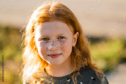 Smiling redhead girl with freckles photo