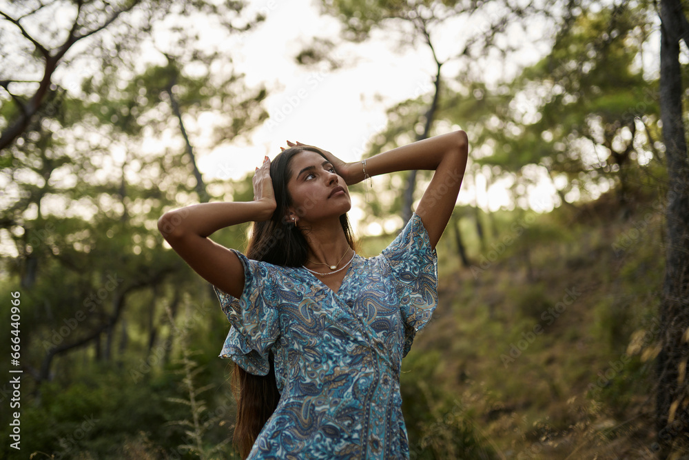 Teenage girl with head in hands standing at forest Teenage girl with head in hands standing at forest